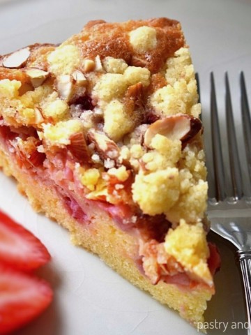 A slice of strawberry crumble cake on a plate.