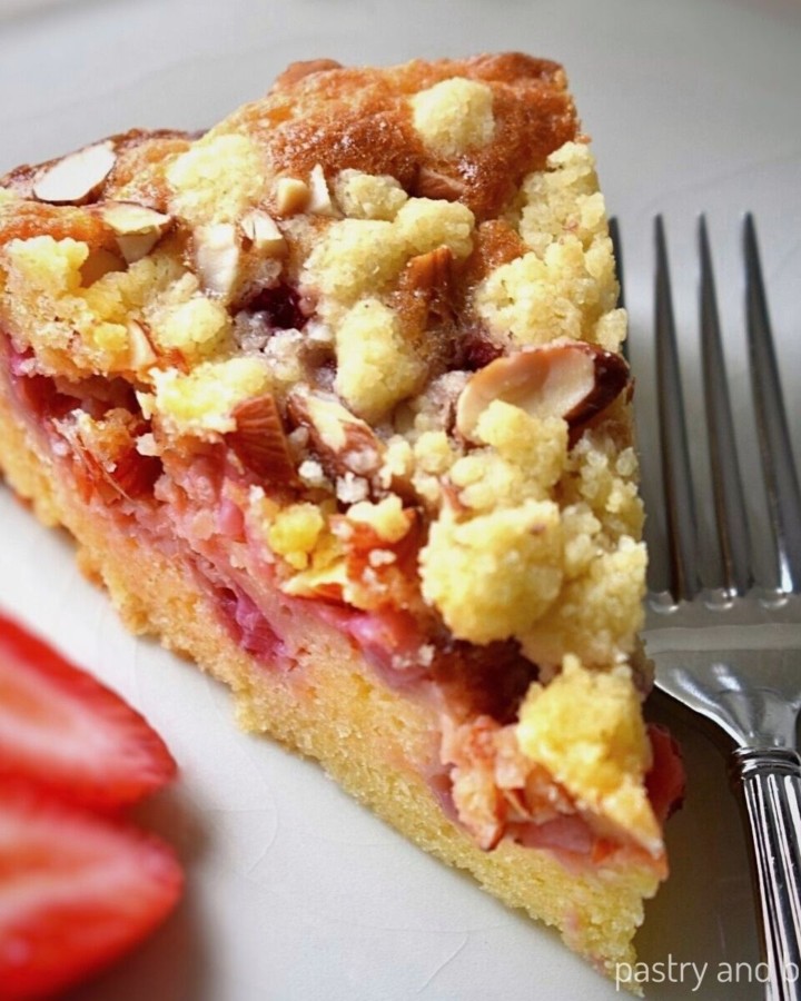 A slice of strawberry crumble cake on a plate.
