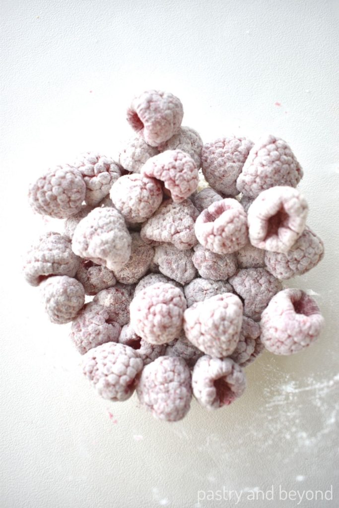 Raspberries that are covered with flour in a bowl.