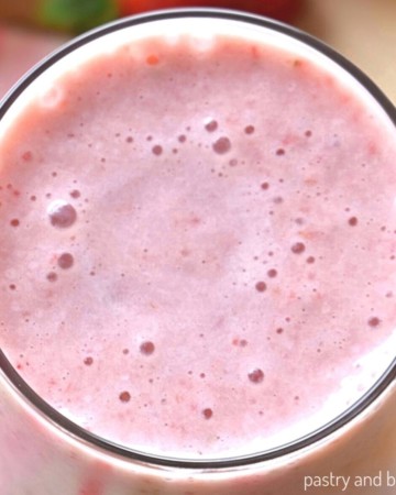 Overhead view of strawberry banana smoothie that is in a large glass.