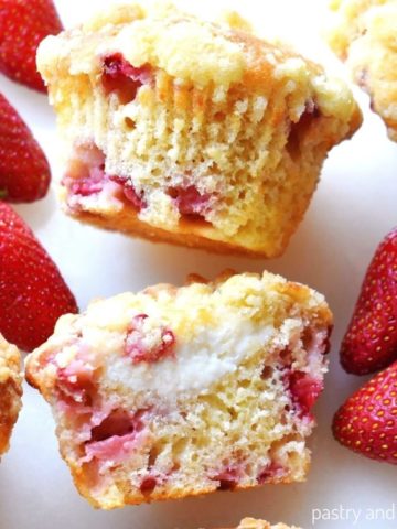 Strawberry cream cheese muffins on a white surface.