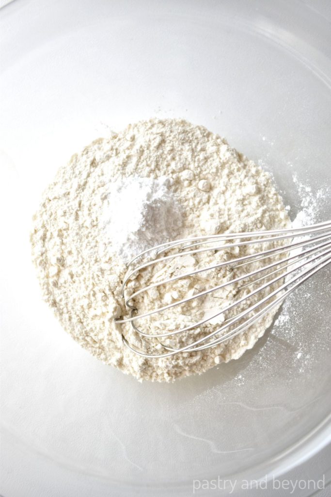 Flour and baking powder in a large bowl with a whisk.