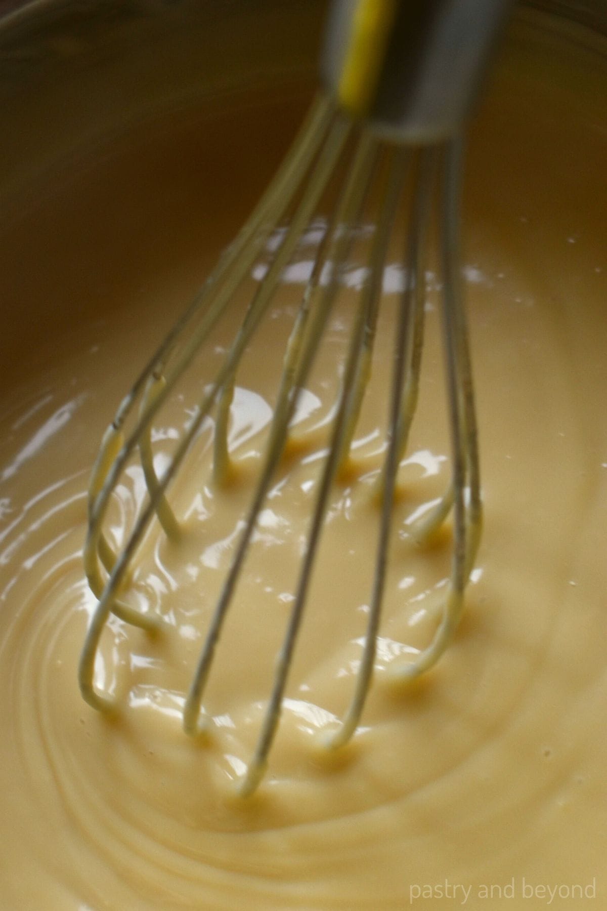 Stirring pastry cream with a whisk.