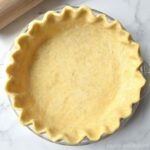 Fluted pie dough in a pie plate.