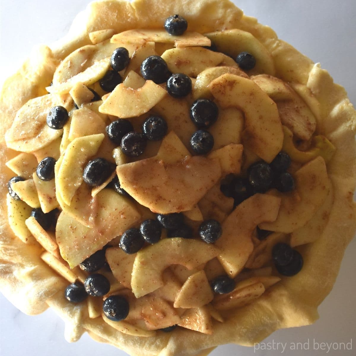 Pie crust that is filled with apple and blueberry filling.