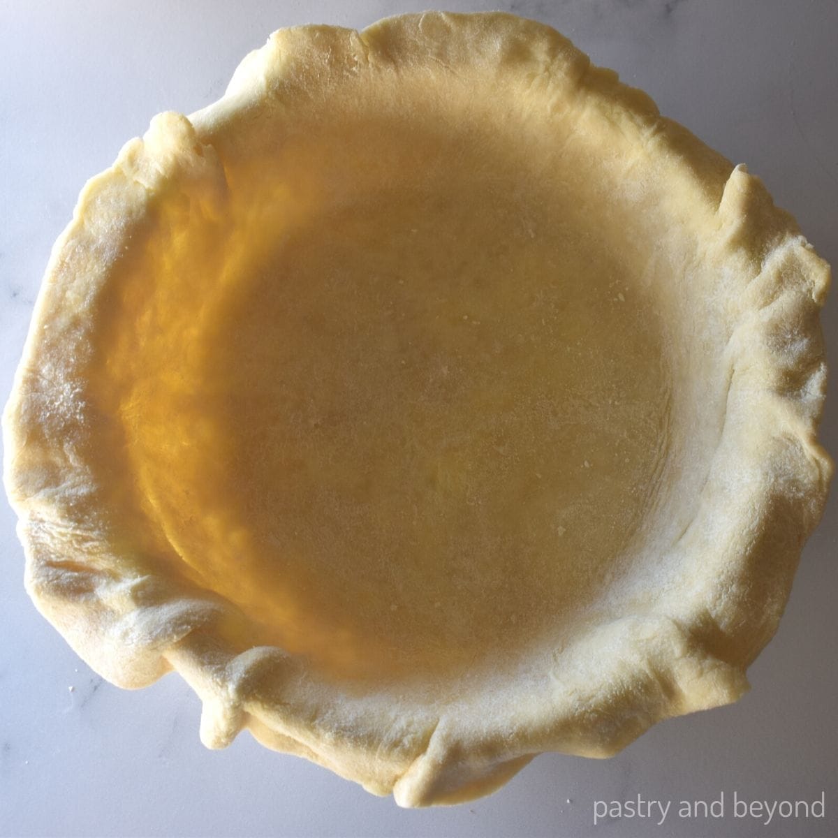 Pie dough lined in a pie plate.
