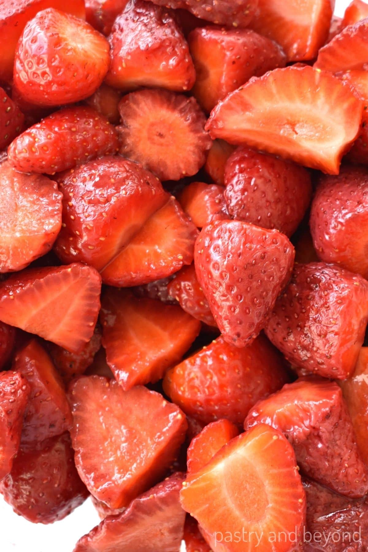 A mix of full strawberries and strawberries in half in a bowl.