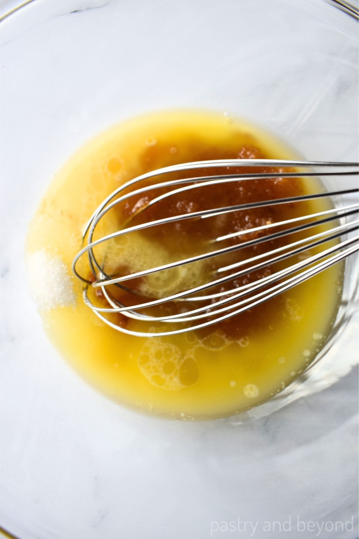 Stirring melted butter, granulated sugar and brown sugar in a large bowl  with a whisk.