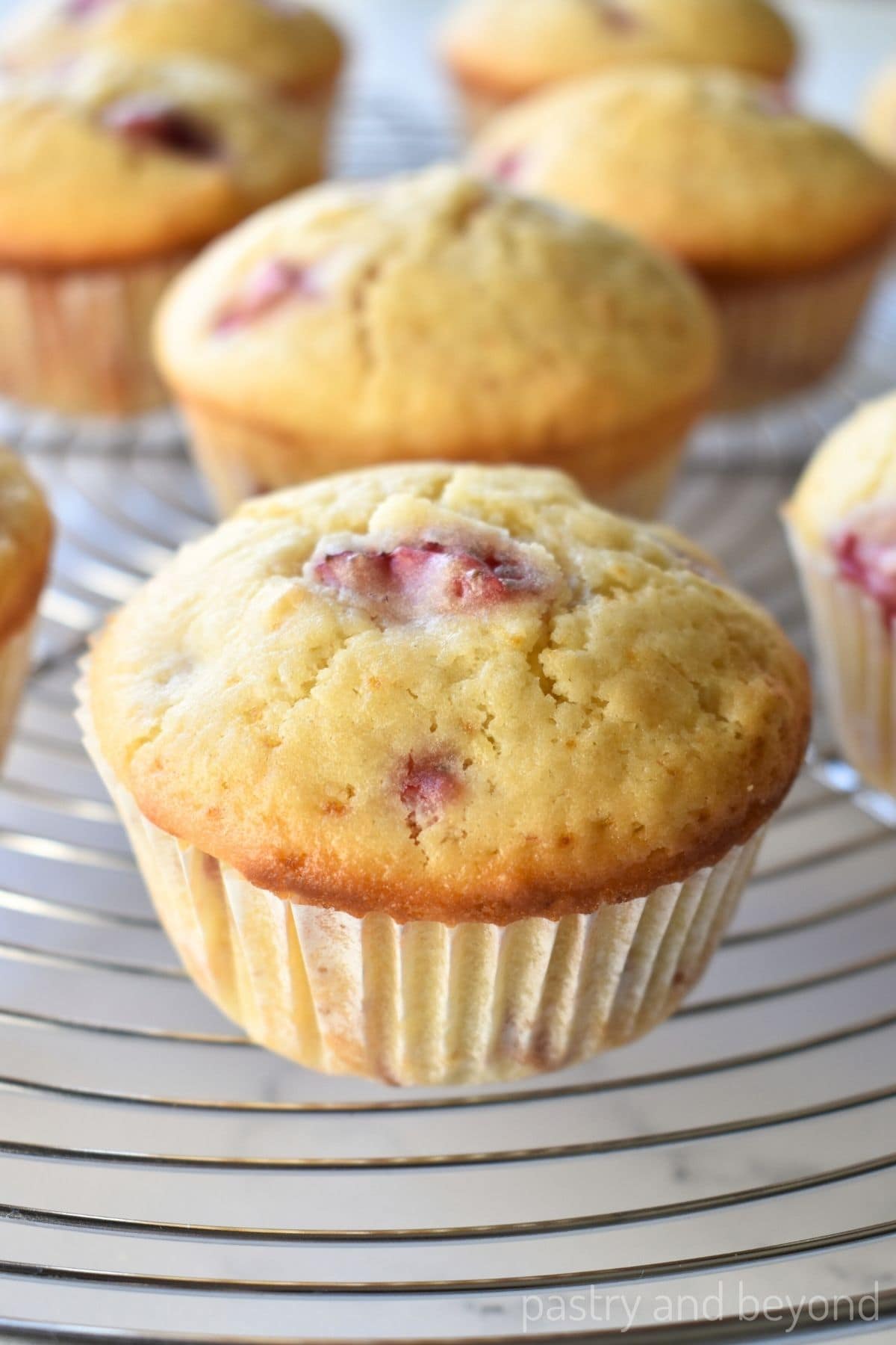 Strawberry lemon muffins on a wire rack.