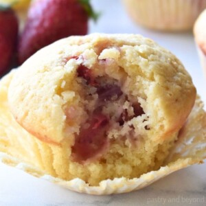Strawberry lemon muffin with a bite taken from it.
