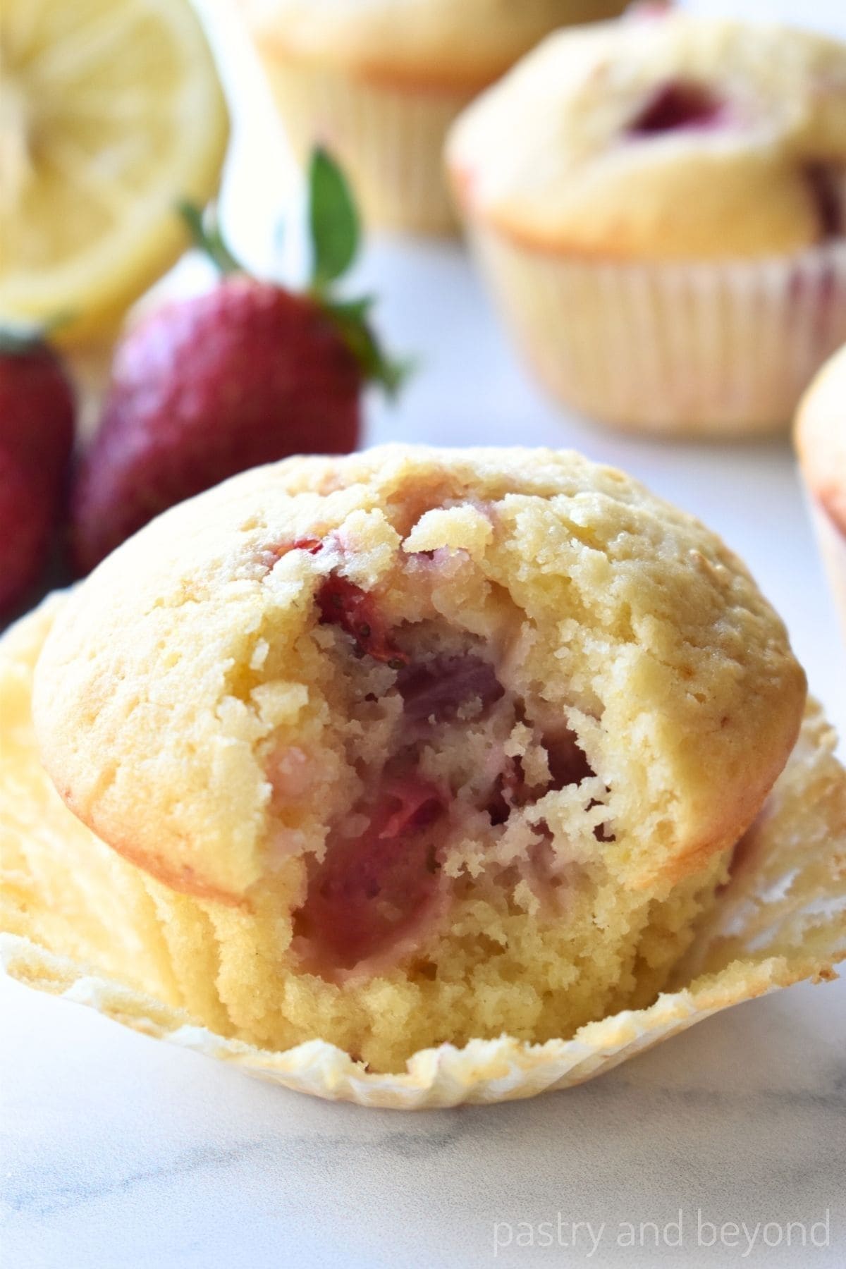 Strawberry lemon muffin with a bite taken from it.
